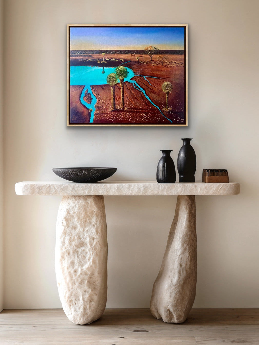 A mixed media textured painting of the dramatic red desert with a turquoise billabong and grass tress and blue sky by Wendy Peters