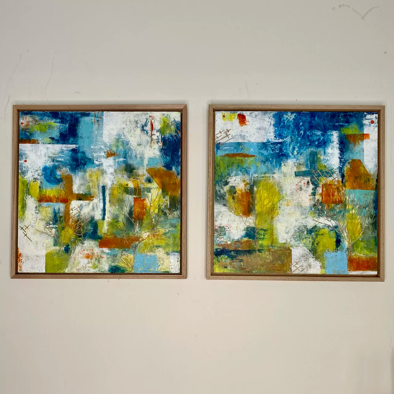 Two abstract cold wax and mixed media paintings on wood panels, framed in oak, with vibrant colors and geometric patterns, 