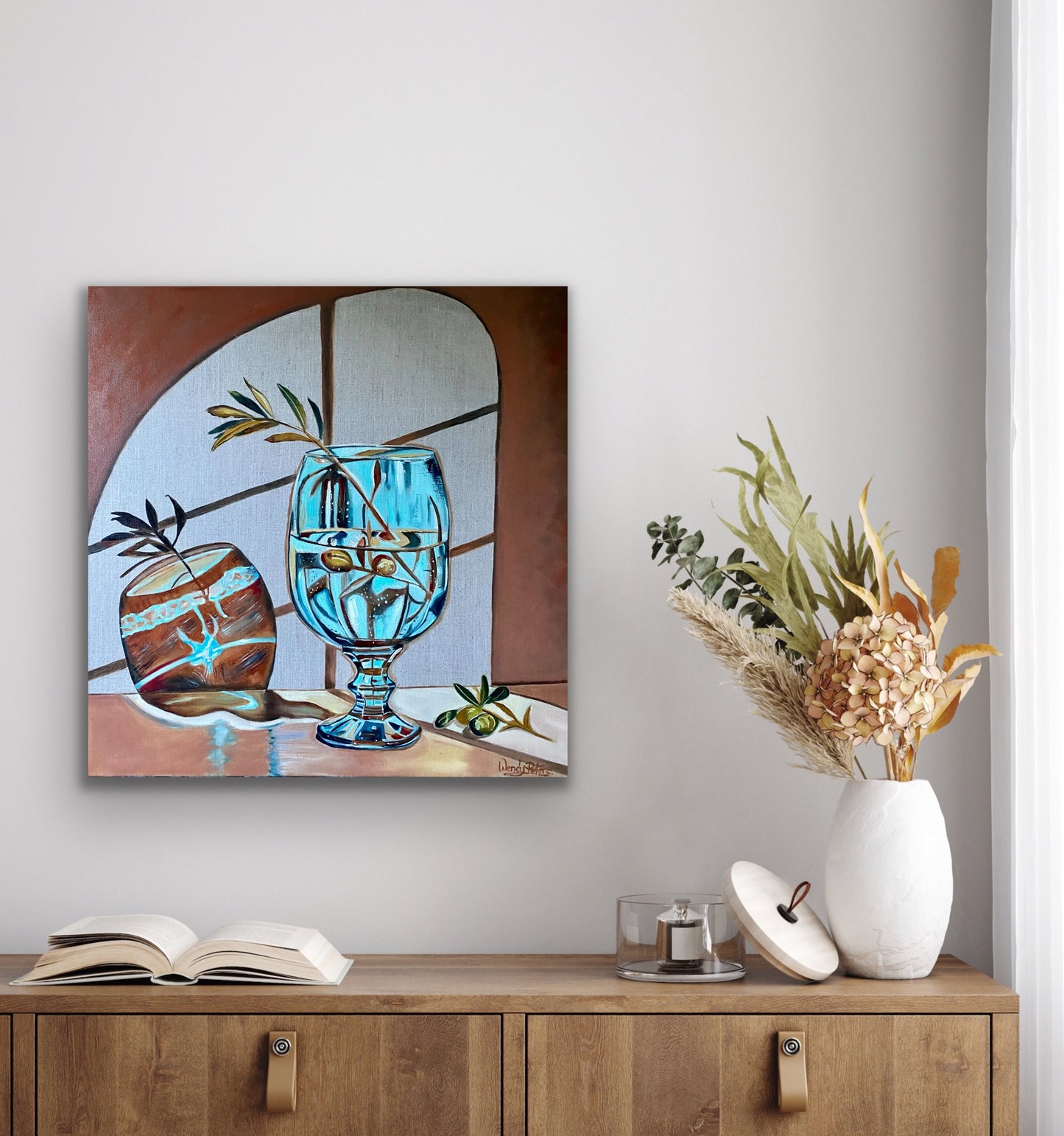 original oil painting of a blue stemmed glass with a single olive branch throwing abstract shadows on a wall with a window in the background by Wendy Peters