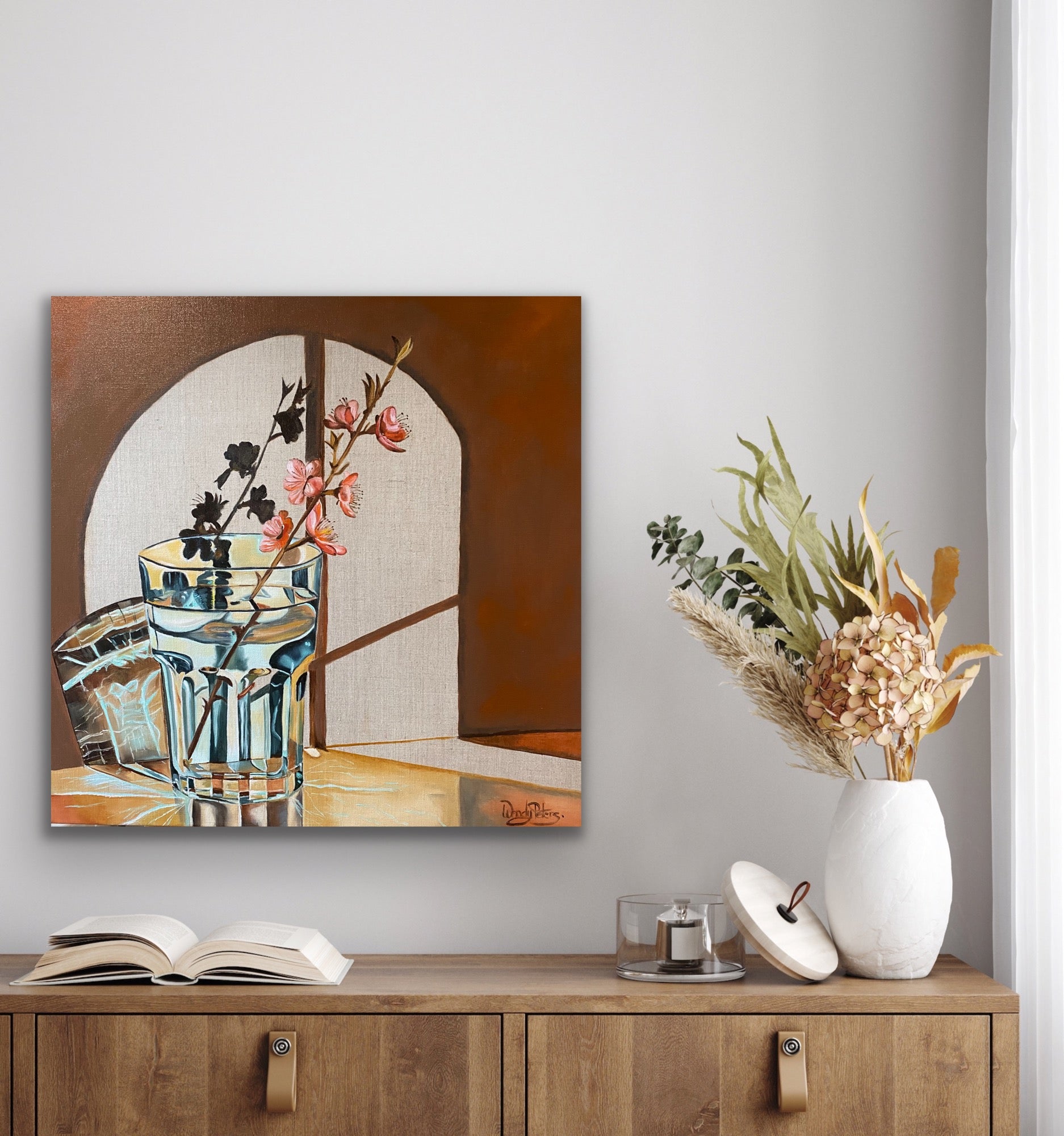 original oil painting of a water glass with a single stem of blossom creating abstract shadows on the wall behind through a window by Wendy Peters