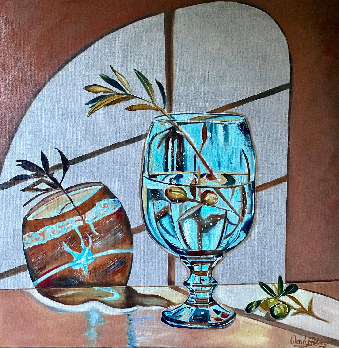 Blue glass and olive branch by Wendy Peters.  A painting of a vivid blue glass with an olive branch in it, with quirky shadows from the glass on the wall behind 